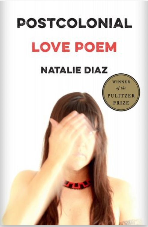Book cover of Postcolonial Love Poem by Natalie Diaz, showing a slightly blurred photo of the author's head, upper torso, and one arm moving across her face, obscuring one side of it. She has bangs and long brown straight hair and is wearing a beaded choker without a shirt