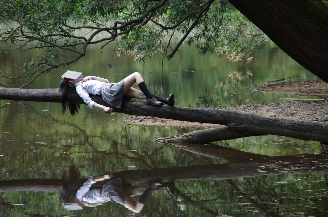 Женщина, лежащая на дереве недалеко от ветра