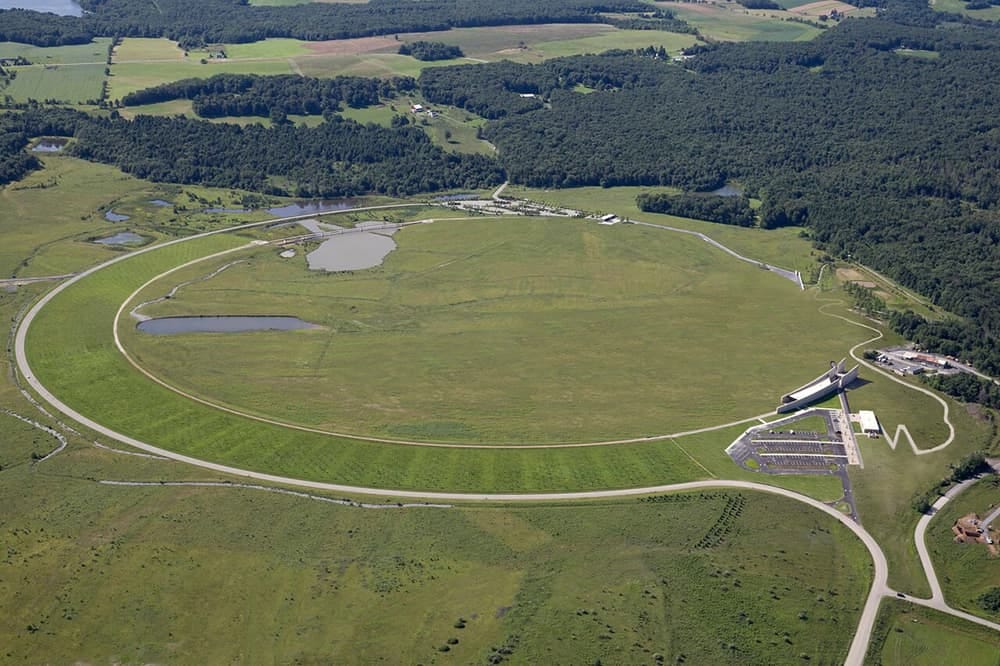 an aerial shot of the Flight 93 memorial site in Shanksville, PA, with a carved round path, open green, and memorial structures for visitors.