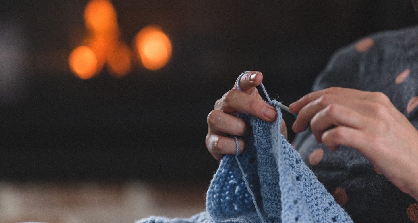 Image of Brooke's hands crocheting a pale blue blanket 