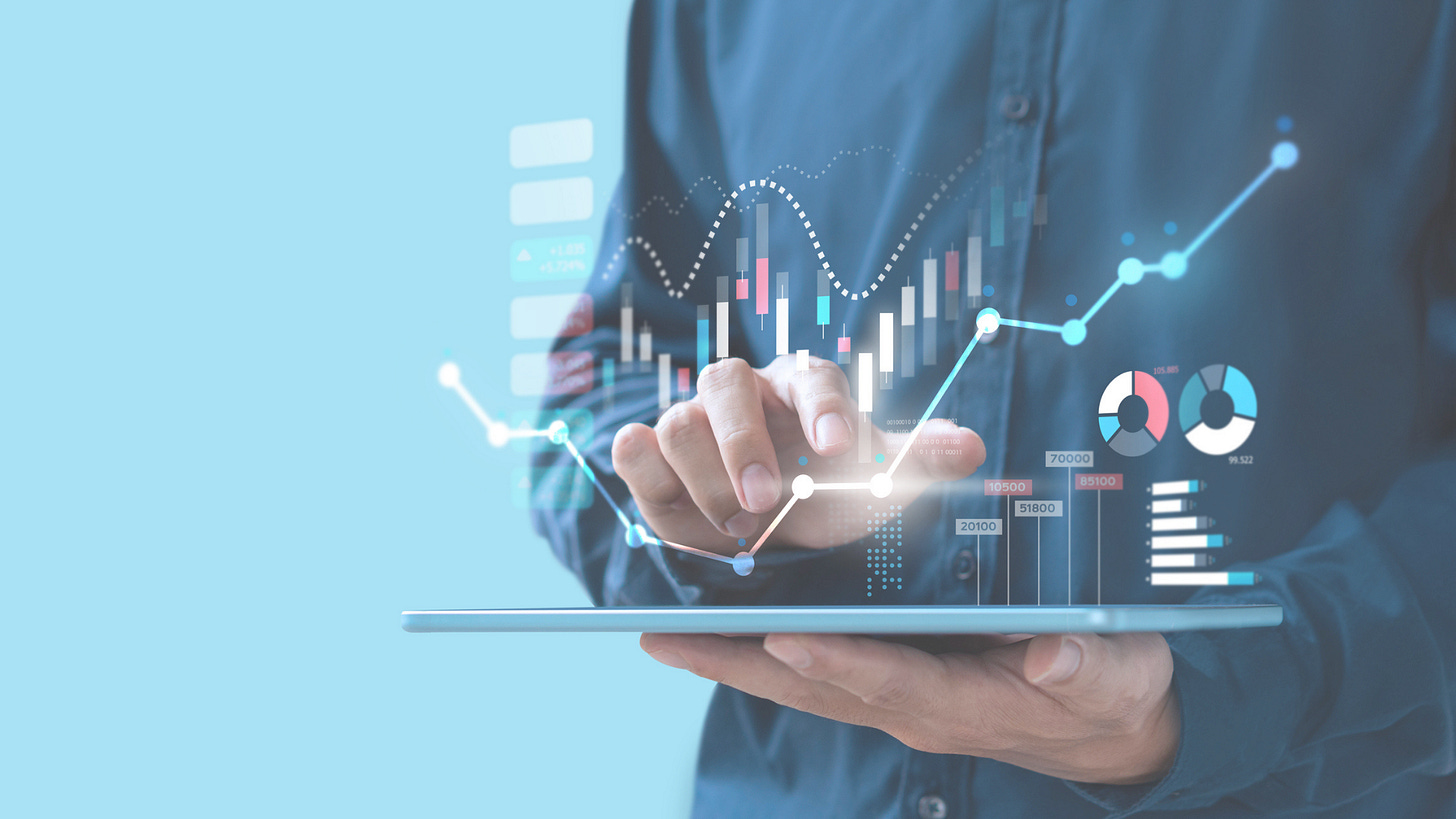 a man's hand showing stock trends, lines and pie graphs