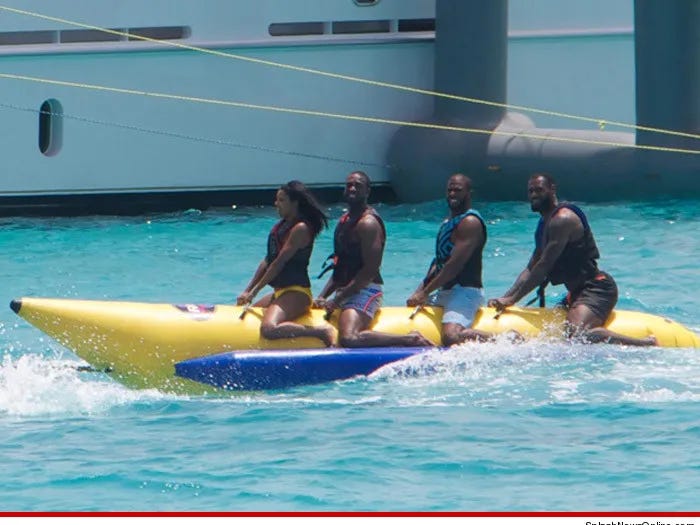 Photo of Gabrielle Union, Dwayne Wade, Chris Paul, and LeBron James on a boat shaped like a banana.