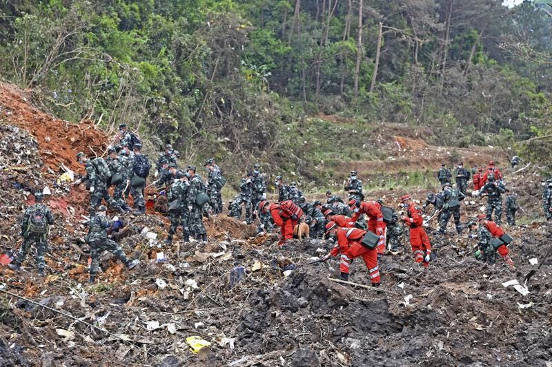 In this photo released by Xinhua News Agency, rescue workers search for the black boxes at a plane crash site in Tengxian county, southwestern China's Guangxi Zhuang Autonomous Region, Tuesday, March 22, 2022. A China Eastern flight 5735 carrying 123 passengers and nine crew members crashed outside the city of Wuzhou in the Guangxi region while flying from Kunming, the capital of the southwestern province of Yunnan, to Guangzhou, an industrial center not far from Hong Kong on China's southeastern coast. It ignited a fire big enough to be seen on NASA satellite images before firefighters could extinguished it. (Zhou Hua/Xinhua via AP)