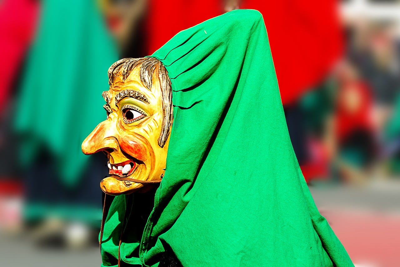 Photo of an old witch costume with a yellow colored mask and green hood