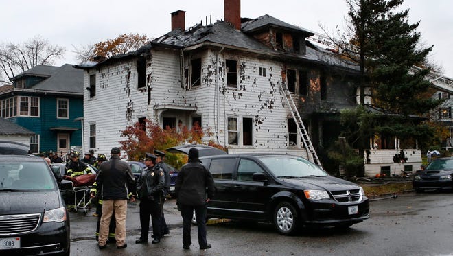 A body is removed Nov. 1, 2014, from the scene of a fatal apartment building fire in Portland, Maine. Earlier in the morning, a fire swept through the two-apartment building housing students from the University of Southern Maine.