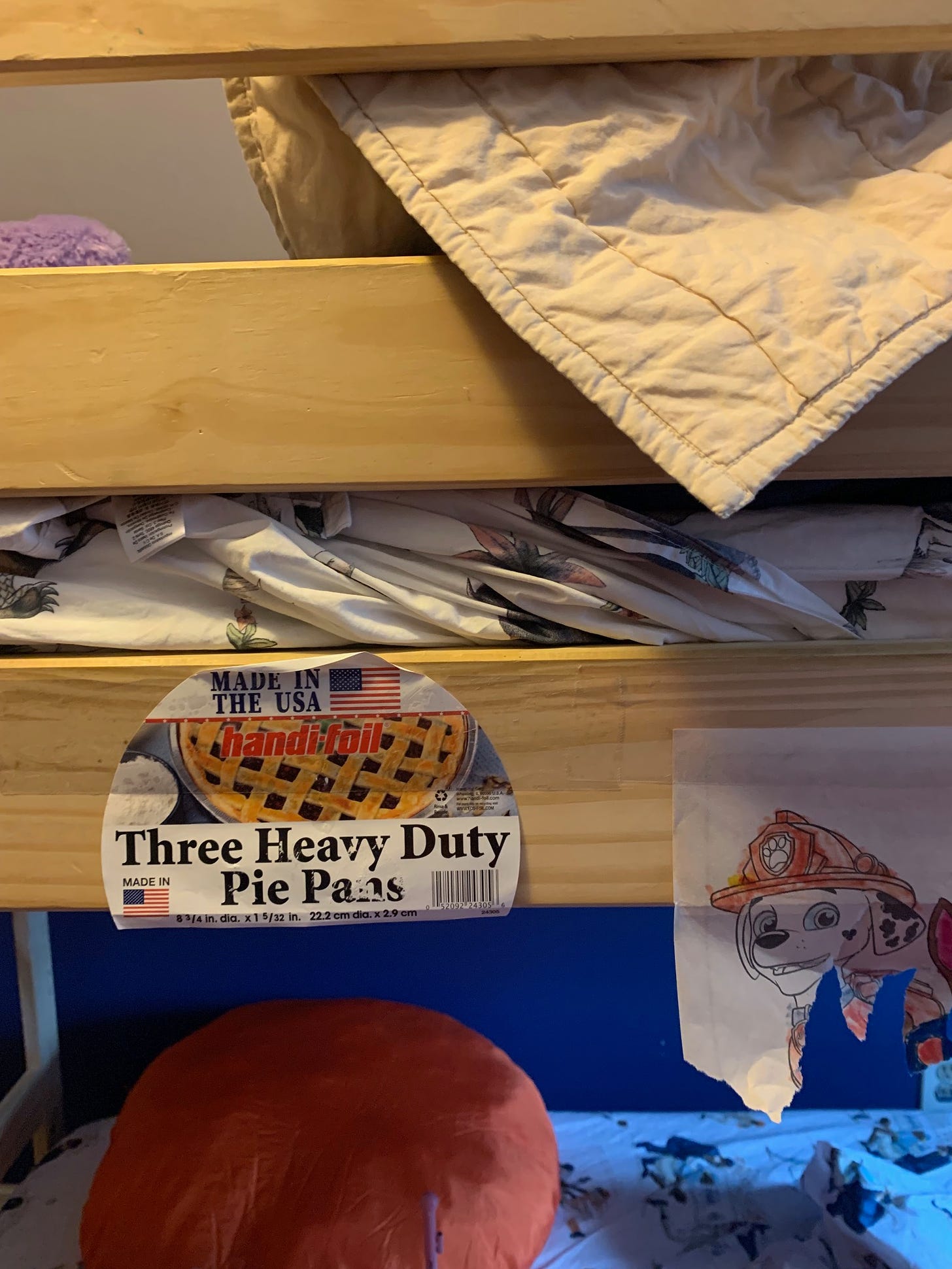 A bunk bed with a "3 heavy duty pie pans" sticker on the rail