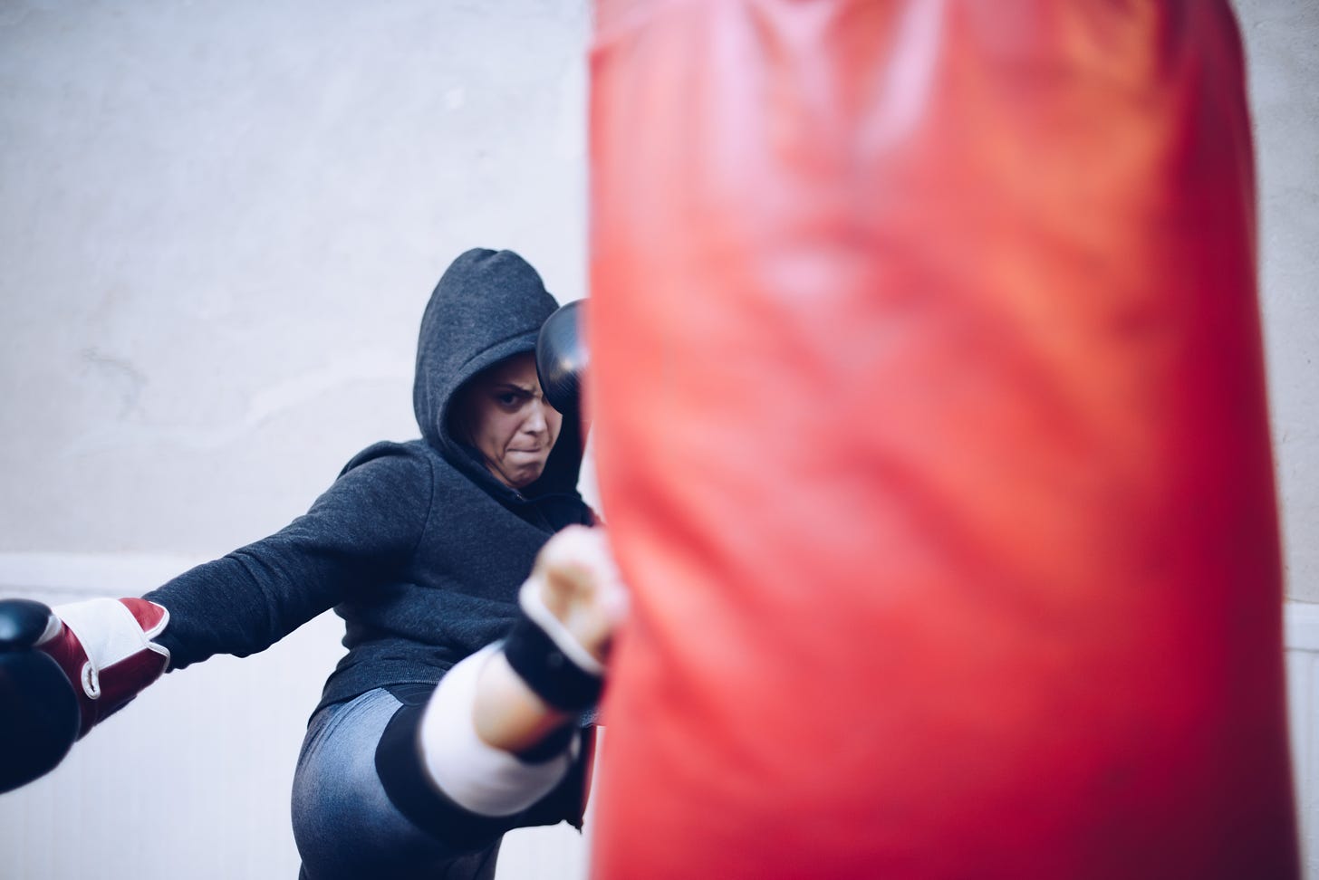 Woman fighter kicking a heavy bag