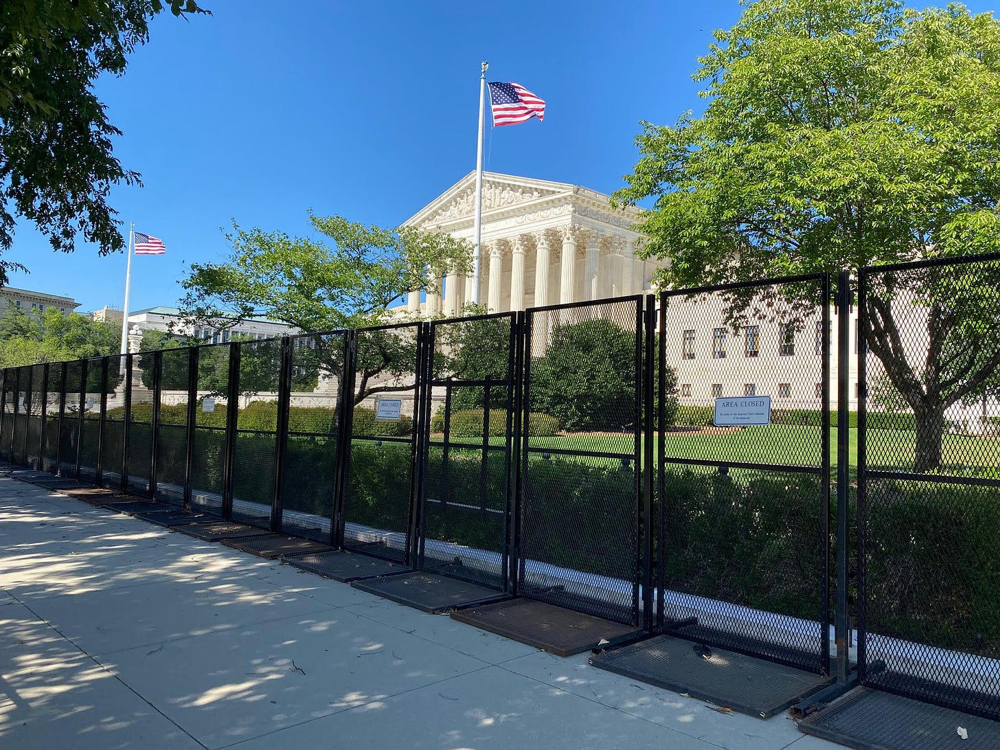 The Supreme Court building, behind a tall black fence that surrounds the grounds.