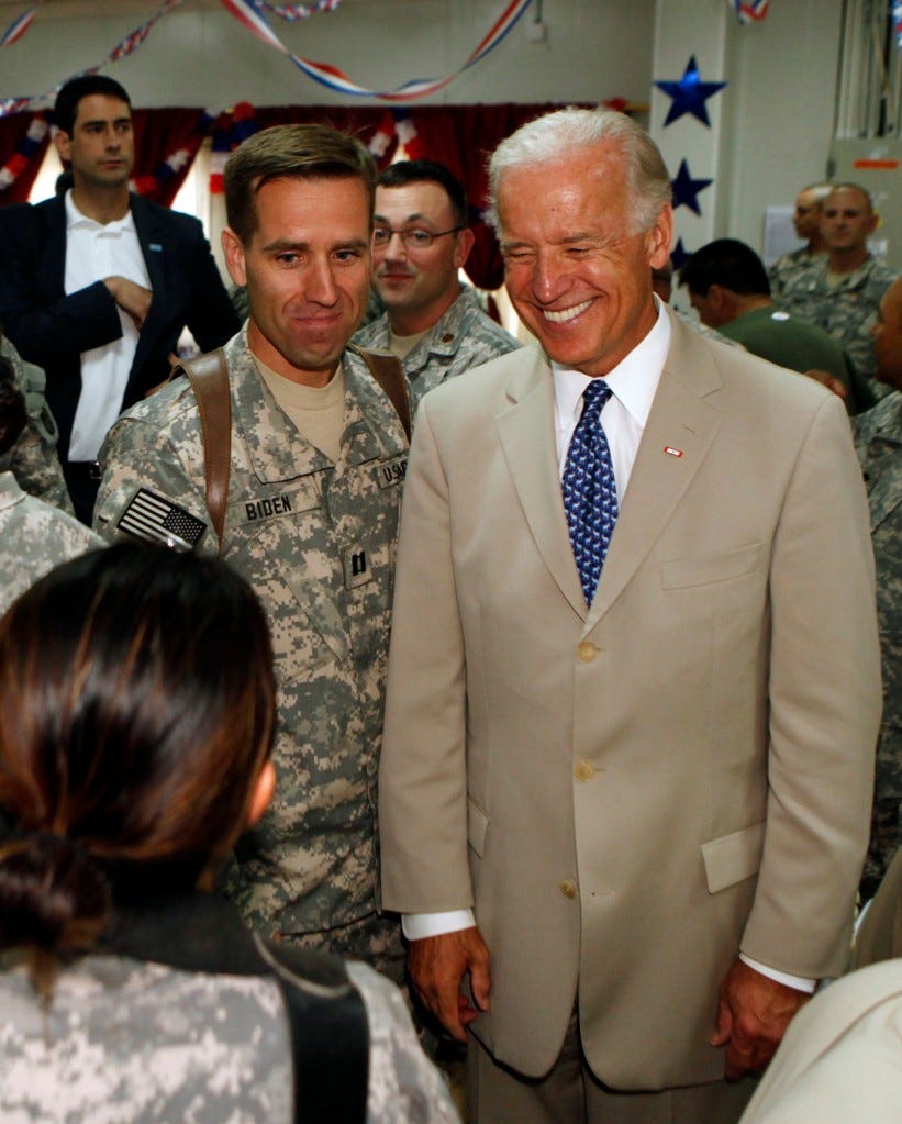 President Biden poses with his son, Army Capt. Beau Biden at Camp Victory on the outskirts of Baghdad, Iraq on July 4, 2009.