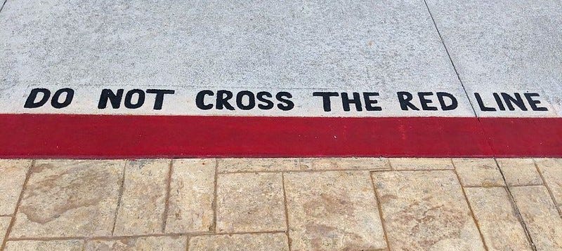 A red line on the floor with a text "Do not cross the red line" above it
