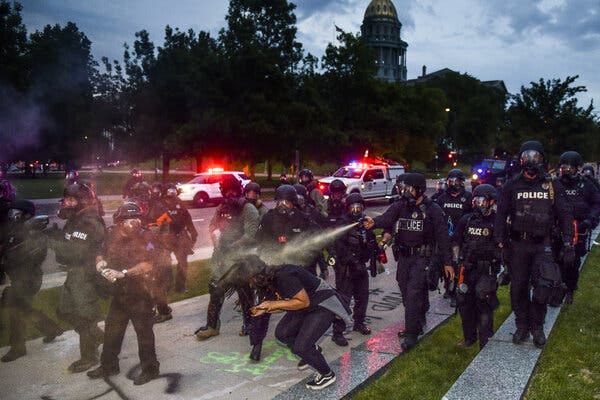Police officers in Denver pepper spraying a woman during the 2020 protests  over the death of George Floyd.