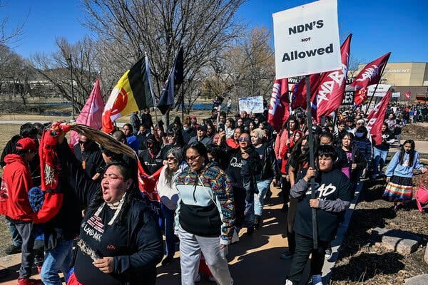 Hundreds of people marched in Rapid City, S.D., on Wednesday, the day a federal lawsuit was filed against the Grand Gateway Hotel, accusing it of denying services to Native Americans.