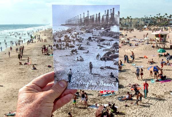 A historic photograph of Huntington Beach with oil wells along...
