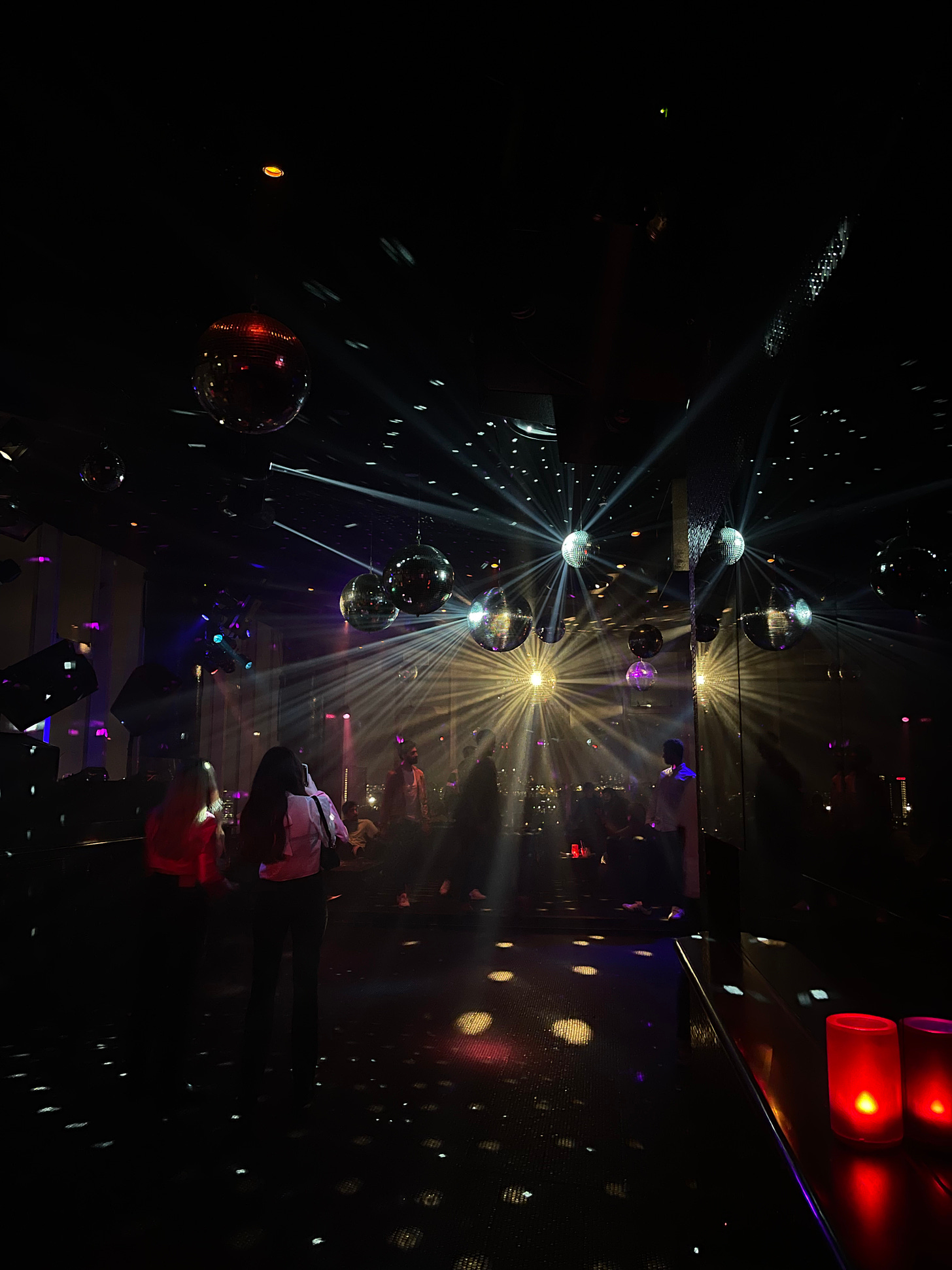 dancefloor lit up with disco balls and mirrors