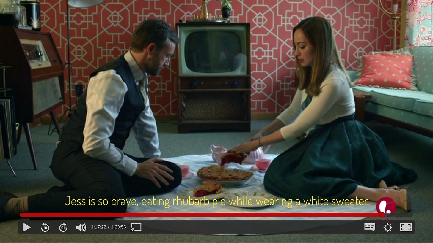 Jess and Simon eating on the floor of a colorful living room, captioned "Jess is so brave, eating rhubarb pie while wearing a white sweater"