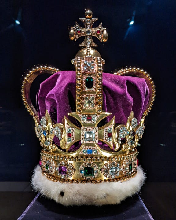 Large gold crown decorated with diamonds and red, green, blue, and purple gemstones