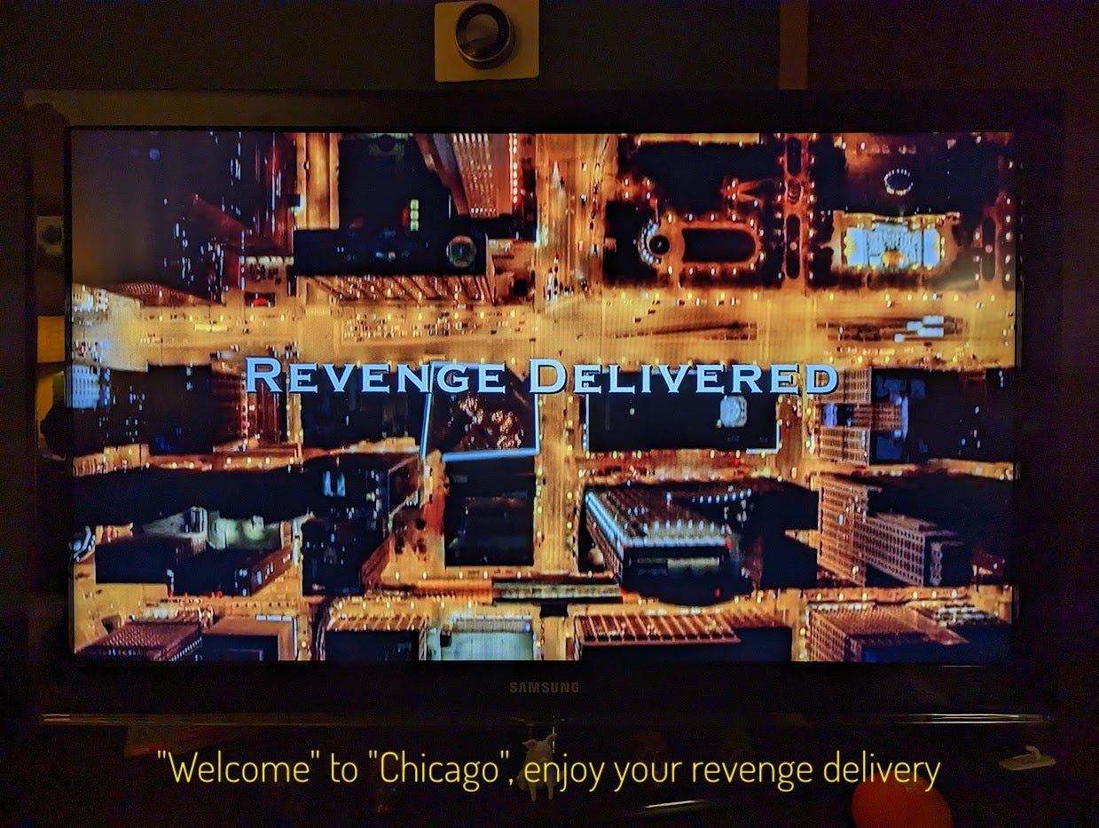 An overhead shot of Chicago at night, with the title on top. Captioned "'Welcome' to 'Chicago', enjoy your revenge delivery"