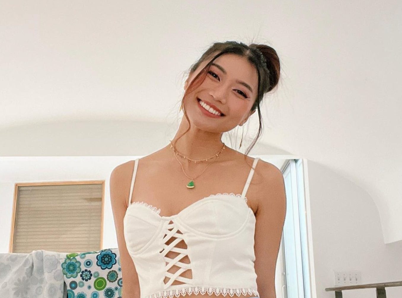 Rosie Nguyen smiling at camera in a white tank top