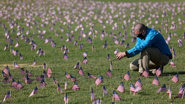 Chris Duncan, whose 75-year-old mother Constance died from COVID-19 on her birthday, photographs a COVID-19 Memorial Project installation of 20,000 American flags on the National Mall as the United States crosses the 200,000 lives lost in the COVID-19 pandemic on Sept. 22, 2020 in Washington, D.C. The U.S. will likely cross the mark of half a million lives lost to COVID-19 in the coming days.