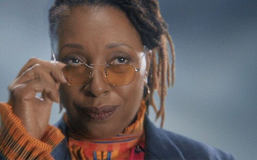This image shows the Fugitive Doctor (played by Jo Martin) gazing at the offscreen Thirteenth Doctor. The Fugitive Doctor clasps her sunglasses right before removing them from her face. This image shows the Fugitive Doctor (played by Jo Martin) gazing at the offscreen Thirteenth Doctor. The Fugitive Doctor clasps her sunglasses right before removing them from her face.