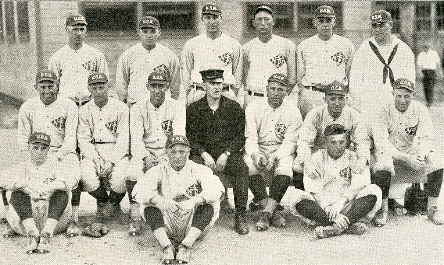 The 1918 Great Lakes baseball team included three players who started on the football team as well. Outfielder George Halas stands second from left. Pitcher Jerry Jones stands third from right and infielder Paddy Driscoll is seated on the far left. (Great Lakes Recruit, July 1918)