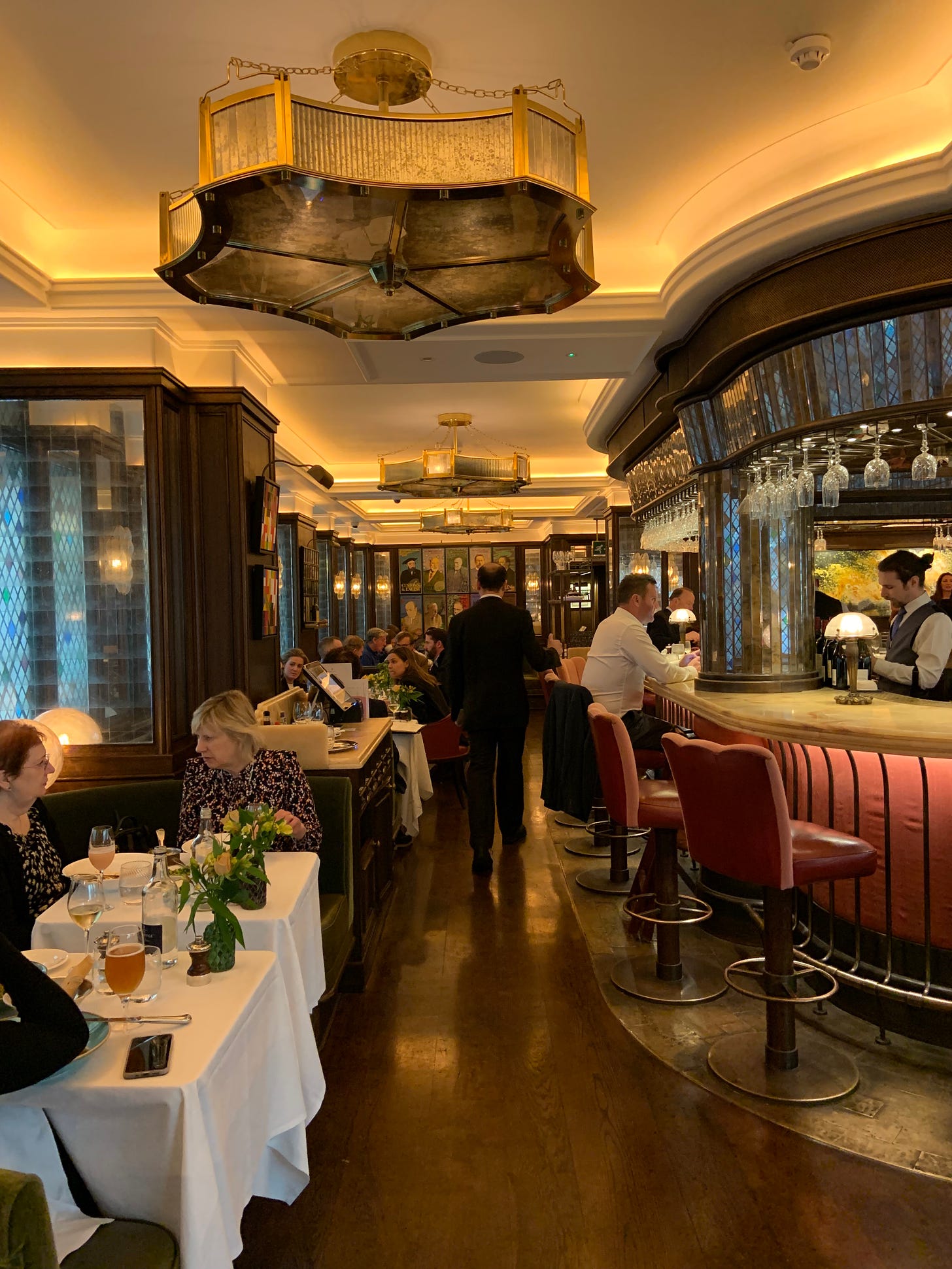 photo of the inside of the Ivy restaurant in London, showing the bar and diners seated at tables