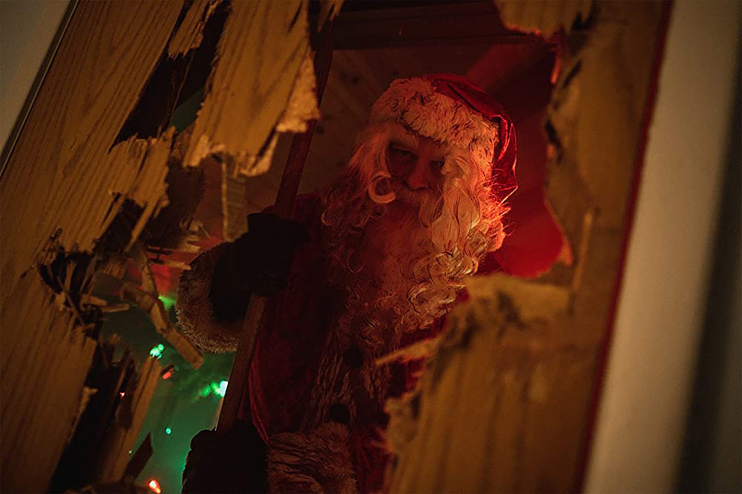 CHRISTMAS BLOODY CHRISTMAS film still with Abraham Benrubi’s robotic Santa bursting through a door with an axe.