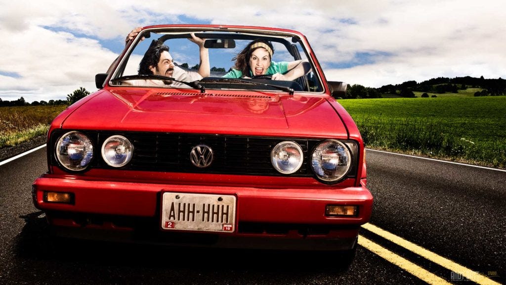 Billboard campaign for Oregon Lottery Powerball. One crazy driver and one very scared passenger in a red car on the road, looking like they may be driving off a cliff. The license plate reads "AHH-HHH"
