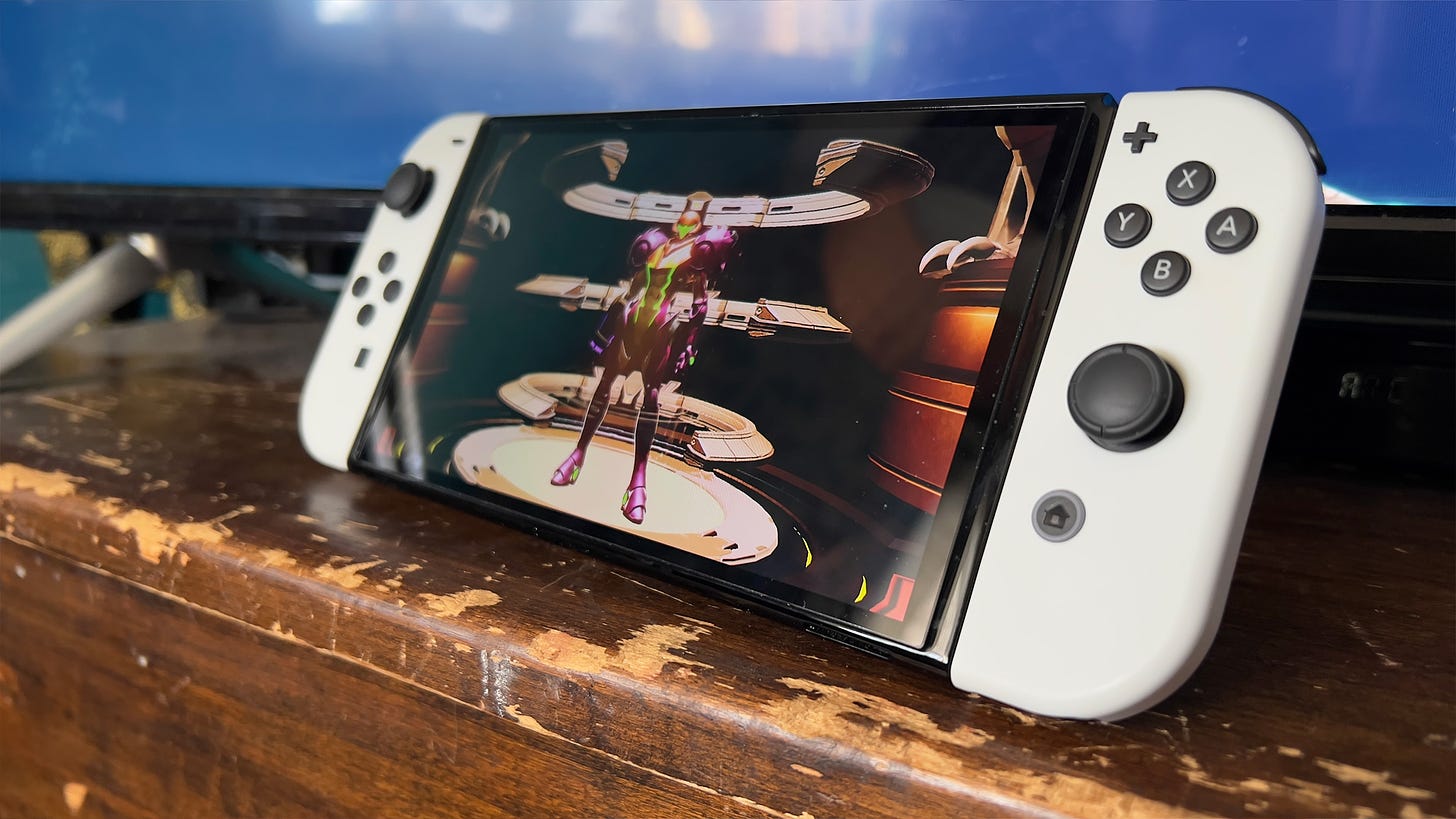 A Switch OLED sits on a wooden surface, displaying Metroid Dread
