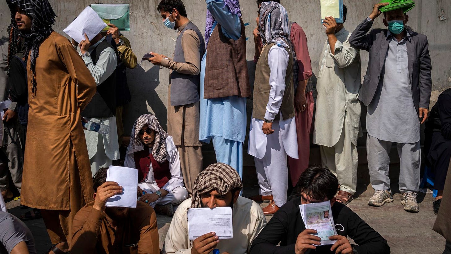 Afghans line up outside the Iranian Embassy to request travel visas in Kabul, Afghanistan, Wednesday, Sept. 29, 2021.