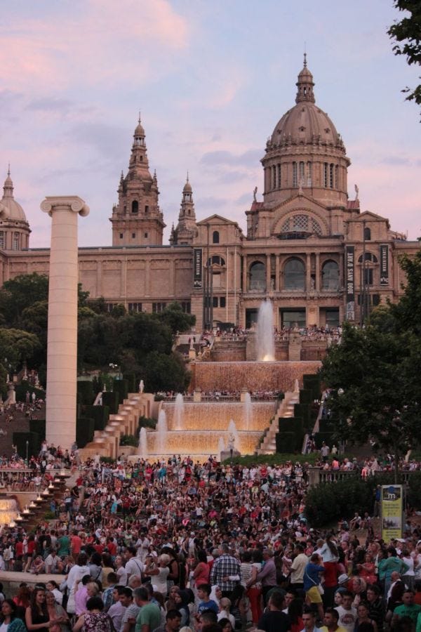 Il palazzo del Museo di Archeologia di Catalogna e le fontane magiche di Barcellona, affollatissime durante il Pride del 2013. Sullo sfondo, il cielo rosa al tramonto.