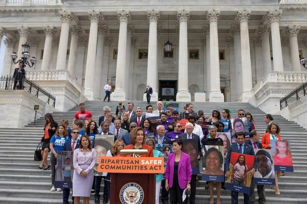 Speaker Nancy Pelosi, center, and other legislators with survivors and families of gun violence victims outside of the Capitol on Friday.