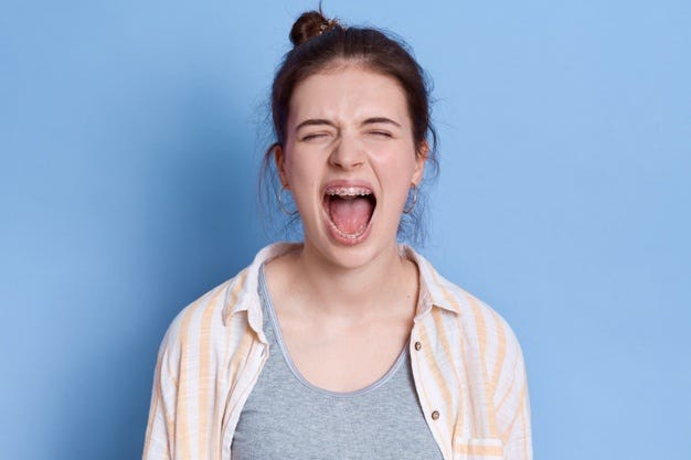 Free Photo | Young emotional angry woman screaming isolated, keeping eyes  closed, looks sad, wearing white shirt and grey t -shirt, brunette lady  yelling angrily.