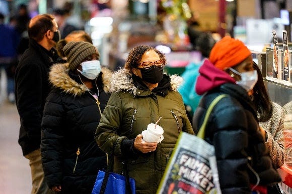Customers wearing face masks to protect against the spread of the coronavirus shop at the Reading Terminal Market in Philadelphia