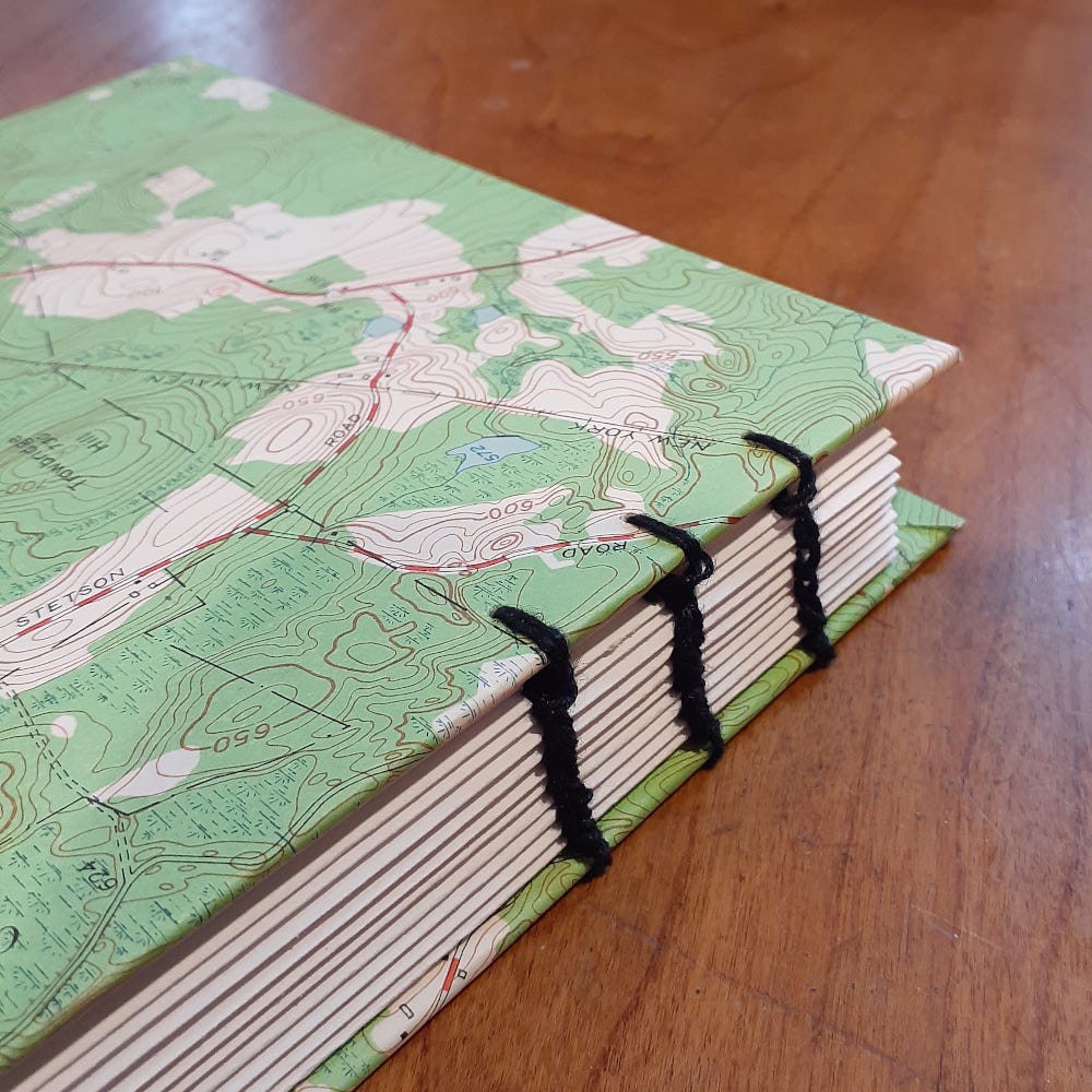 A handmade notebook covered with a mostly green map.