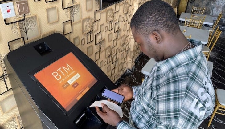 A bitcoin user checks the receipts after buying bitcoins with naira on Bitcoin Teller Machine in Lagos