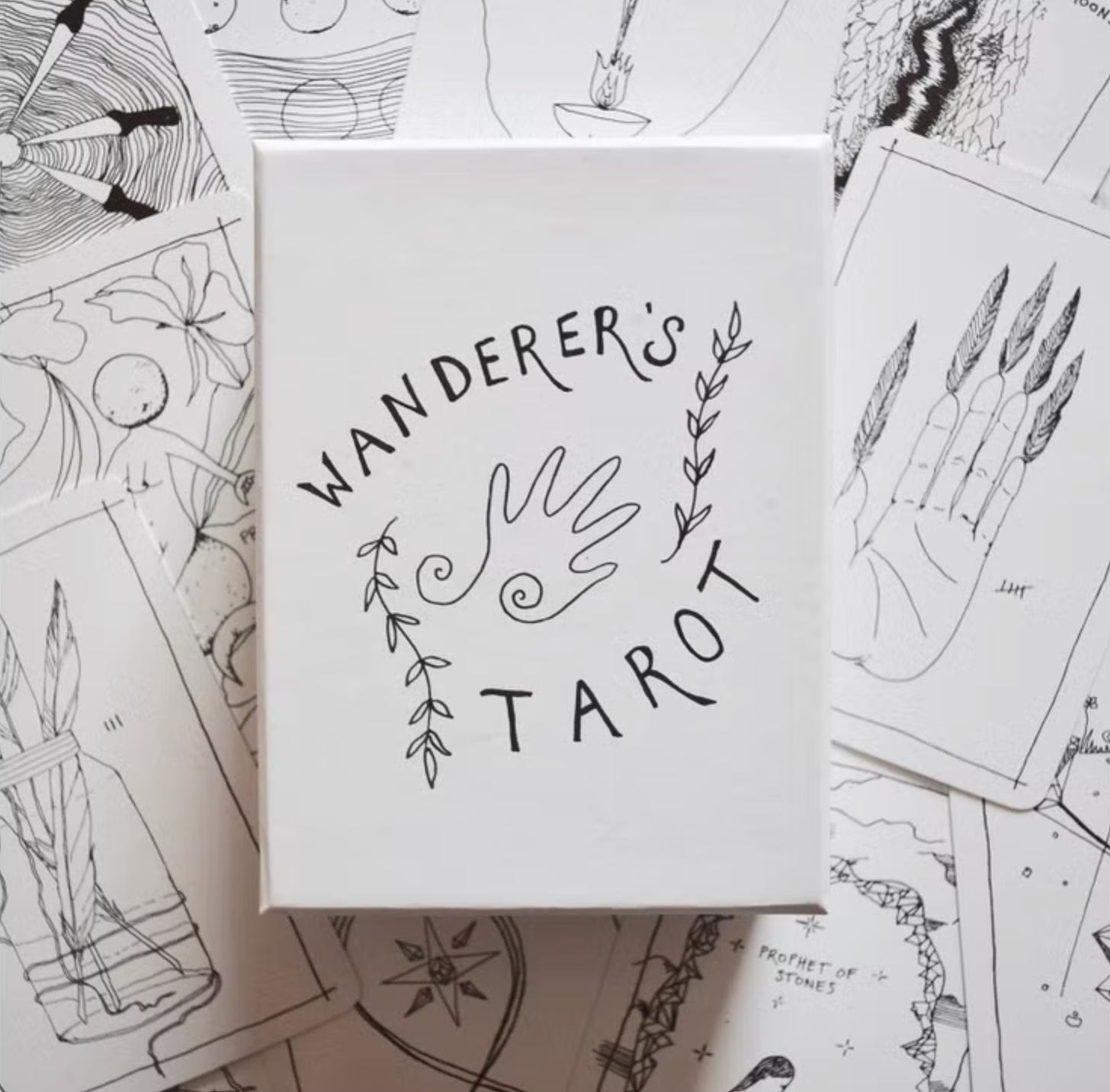 A photo of the Wanderer's Tarot deck (Solar edition), featuring a bunch of tarot cards illustrated with black sketches and the case for the deck in the center.