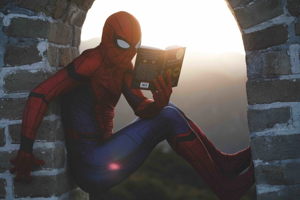 Spiderman increasing his knowledge with a book