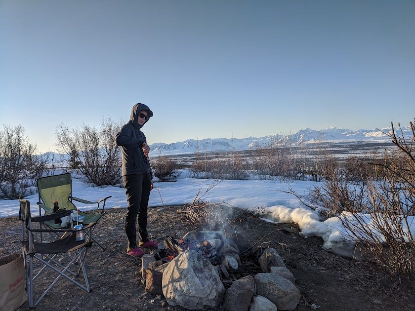 Jules starts a campfire in front of the mountain range