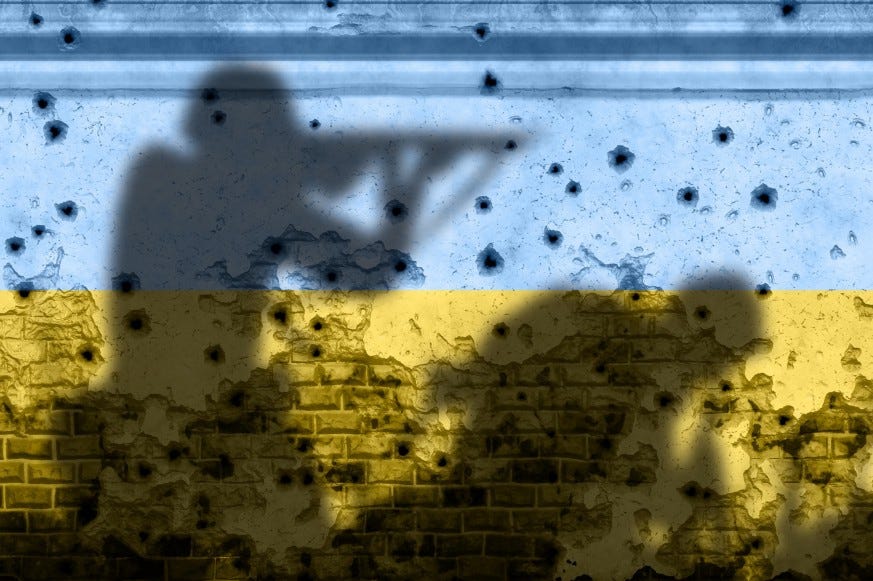 Shadow image of a soldier with a rifle on a wall painted the blue and yellow of Ukrainian flag.