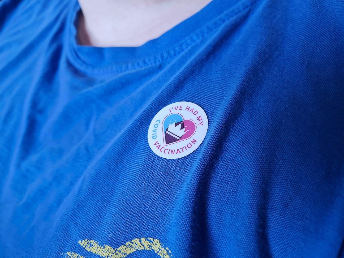 A blue t-shirt with an "I've had my Covid Vaccination" sticker on it