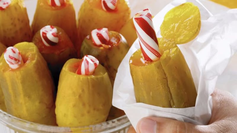 To make the pickle and peppermint stick snack, take a chomp of (or slice) one end of the pickle, stab the middle with the peppermint stick until it goes almost all the way to the bottom, and then eat.
