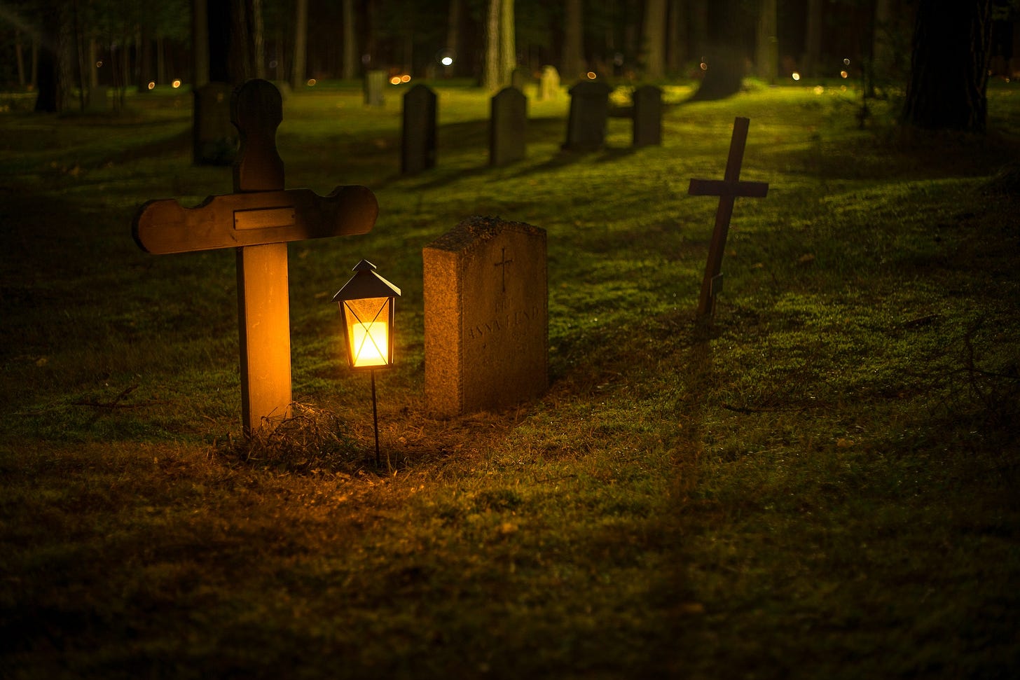 A light beside two gravestones.