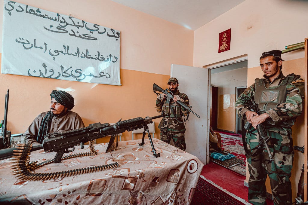 Hafiz Badri, a commander of the Badri 313 brigade, at his office with an American machine gun.