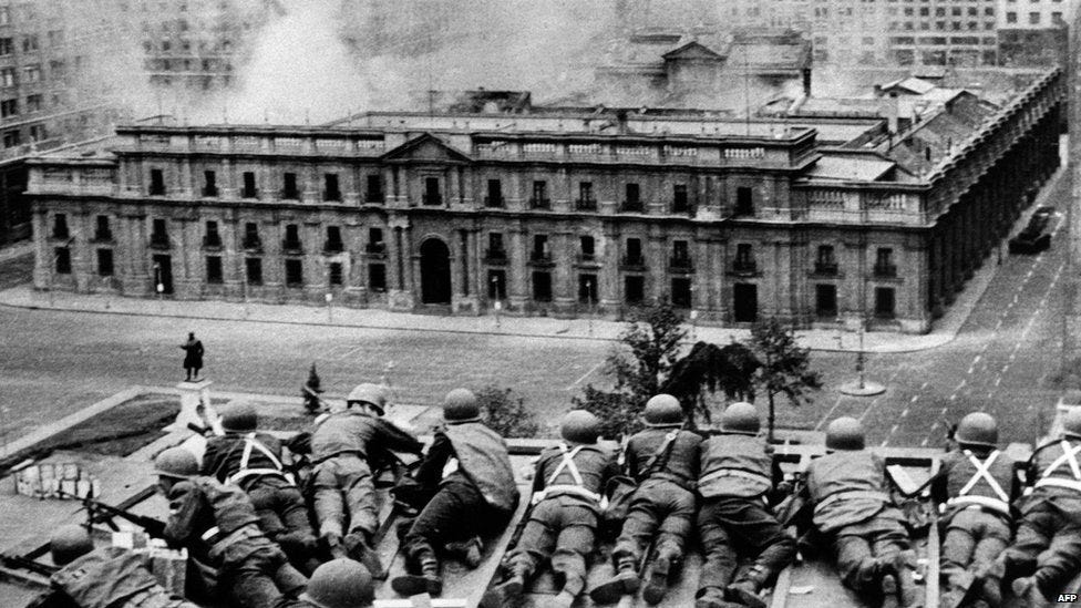 Chilean Army troops positioned on a rooftop fire on the La Moneda Palace in Santiago