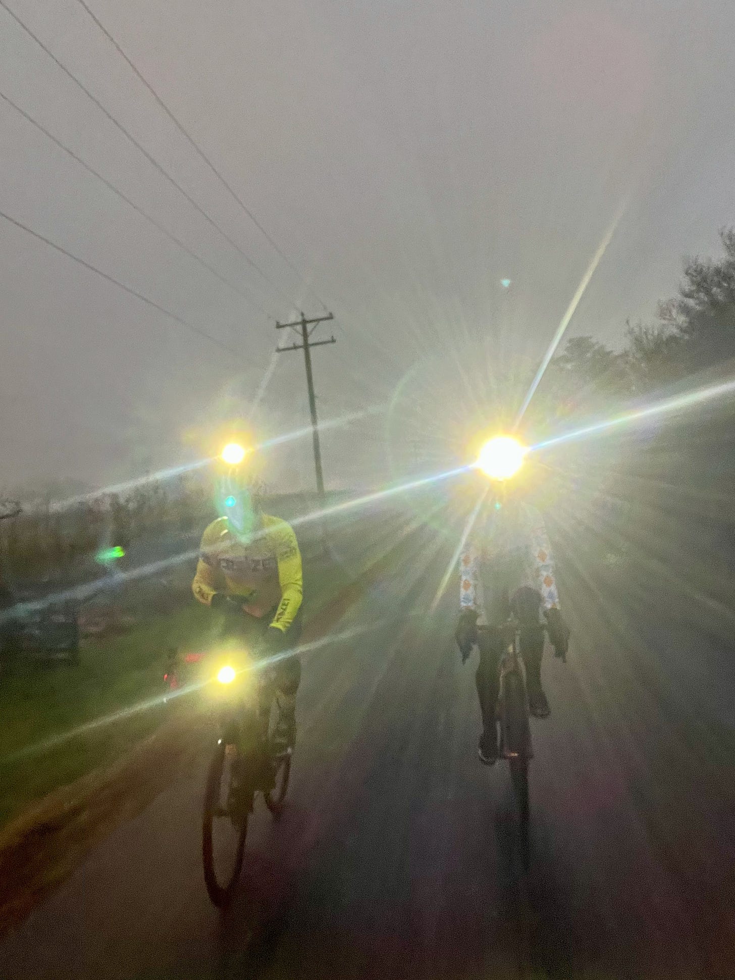 Two people on bicycles in the dark with helmet lights