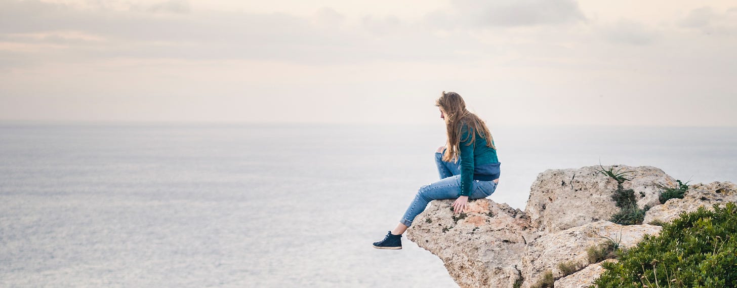 A header image of a woman sitting on the edge of a cliff, one foot hanging over nothingness.