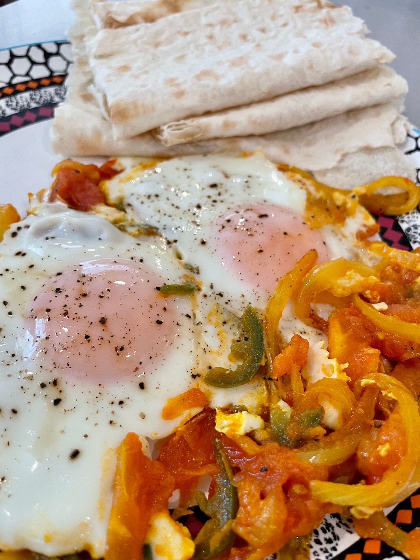 fried eggs with spicy tomatoes onions and lavash