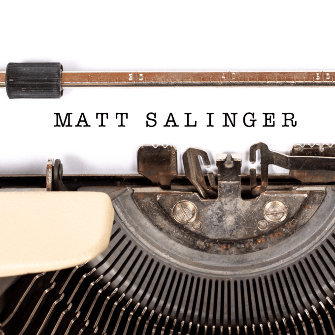 A typewriter with the name, Matt Salinger, typed onto white paper.