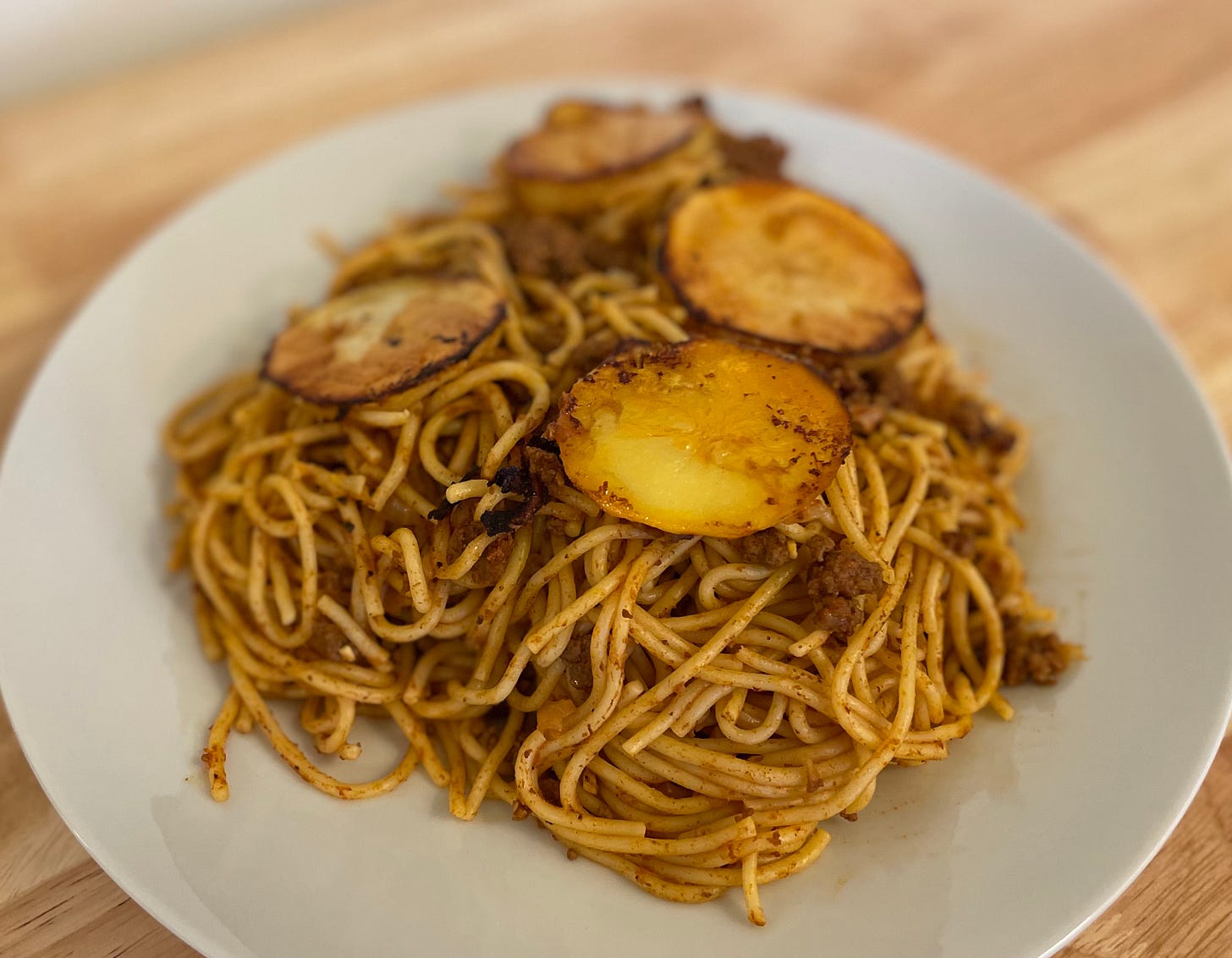 Persian spaghetti and meat sauce served with crispy potatoes